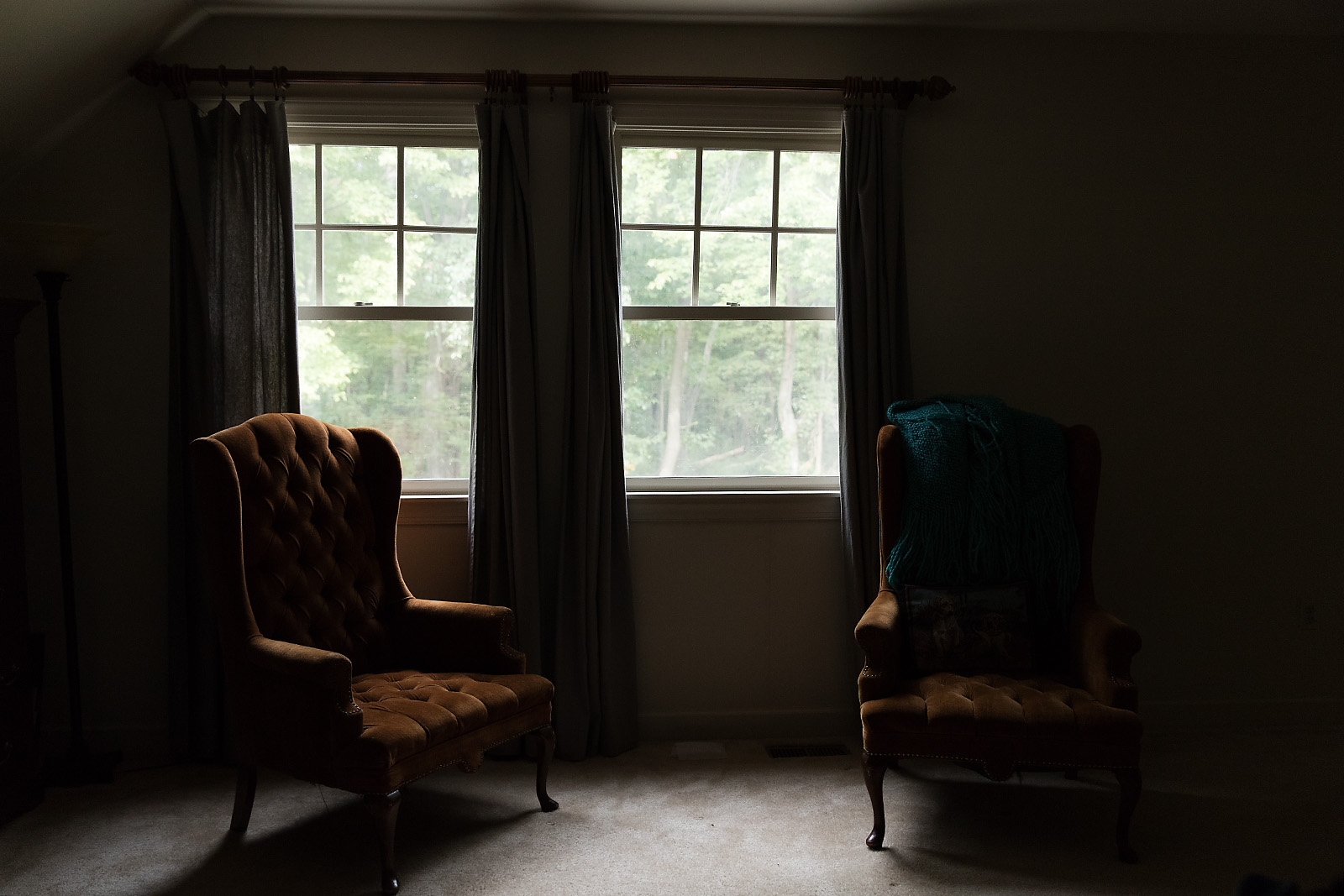 Original low-light image of the same room, with the chairs and curtains in shadow